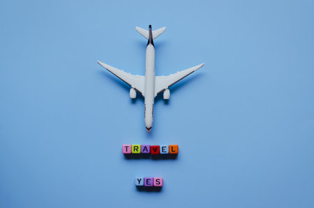 PortoroÅ¾, Slovenia. 04/07/2021. Coronavirus concept. Top view of toy airplane close up, cube beads with words "Travel", "Yes". Traveling with face mask. Creative ideas of prevent COVID - 19.のeditorial素材