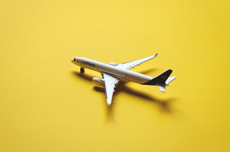 Coronavirus and travel concept. New normal life. Top view of toy airplane close up, medical face mask. Creative ideas of prevent COVID - 19.のeditorial素材