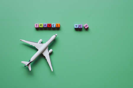 PortoroÅ¾, Slovenia. 04/07/2021. Coronavirus concept. Top view of toy airplane close up, cube beads with words "Travel", "Yes". Traveling with face mask. Creative ideas of prevent COVID - 19.のeditorial素材