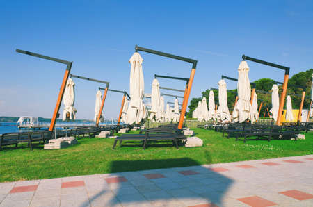 Sun beds and umbrellas on a beautiful tropical beach at the Adriatic coast in Slovenia. Leasure at...
