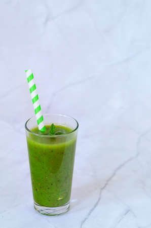 Top view of fresh green healthy smoothie in a glass made of kiwi, chia seeds and banana with mint. Creative concept of healthy detox drink, diet or vegetarian food concept. Copy space.の写真素材