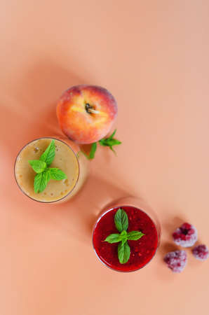 Top view of different fresh delicious smoothies in a glasses made of peach, banana and berries with mint. Creative concept of healthy detox drink, diet or vegetarian food concept. Copy space.の写真素材
