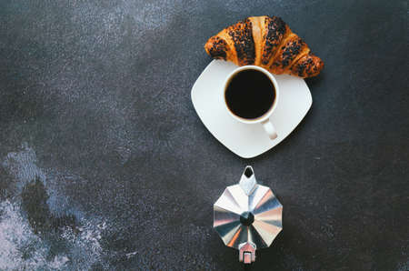 Businessman working morning with notebook, cup of hot coffee and sweet croissant on black background. Top view, copy space, mockup. Flat lay. Modern breakfast food.の写真素材