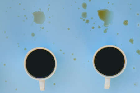 Businessman working morning with cups of hot black coffee and sweet croissant on blue background. Top view, copy space, mockup. Flat lay. Healthy food concept. Modern breakfast food.の写真素材