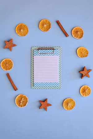 Christmas, New Year flat lay on blue background. Christmas decorations with dry spices, orange...