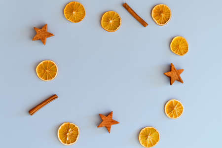 Christmas, New Year flat lay on blue background. Christmas decorations with dry spices, orange...