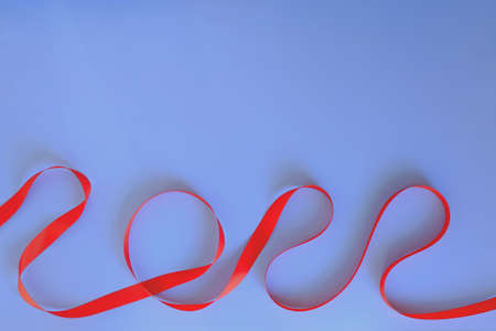 Christmas, New Year flat lay on blue background. Numbers 2022 making with red ribbon. Top view. Copy space. Mock up. Creative ideas of holiday greeting card.の写真素材