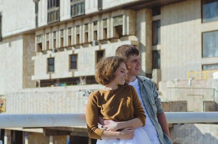 Kharkiv, Ukraine. 09.19.2021. Love story of stylish funny couple: young man in a t-shirt. And a cute young woman in wedding white skirt and yellow sweater. Family holiday and togetherness, dateのeditorial素材