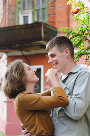 Kharkiv, Ukraine. 09.19.2021. Love story of stylish funny couple: young man in a t-shirt. And a cute young woman in wedding white skirt and yellow sweater. Family holiday and togetherness, dateのeditorial素材