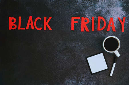 Black Friday concept. Inscription black friday, coffee cup, mobile phone on black background. Copy...