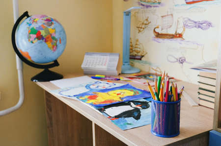 Back to school. home with backpack full of books, pencils. Kid is drawing, writing and painting. School, remote, online educationの写真素材