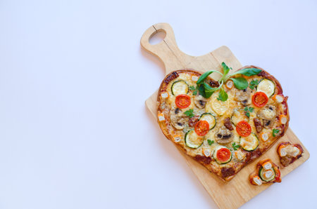 Heart shaped pizza with tomatoes, vegetables and cheese for Valentine's Day on background. Creative food concept of romantic love. Top view, flat lay.の写真素材