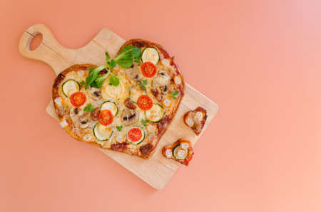 Heart shaped pizza with tomatoes, vegetables and cheese for Valentine's Day on background. Creative food concept of romantic love. Top view, flat lay.の写真素材