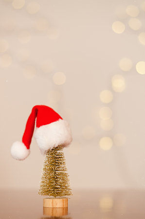 Red Santa Claus hat on toy Christmas tree with bokeh background close up. Top view. New Year mood. Greeting card. Party and holiday celebration concept.の写真素材