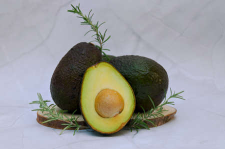 Slices of fresh avocado with herbs and lemons lies on the table on a blue plate. flat lay. top view....