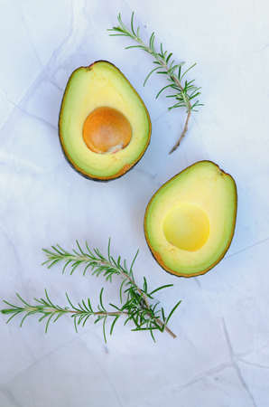 Slices of fresh avocado with herbs and lemons lies on the table on a blue plate. flat lay. top view....