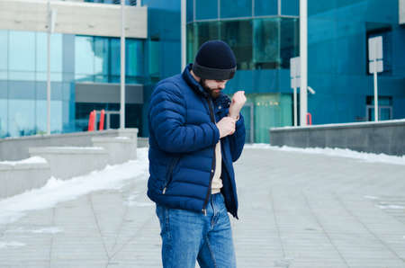 Urban portrait of young elegant business man in winter casual clothes, jacket, hat. Walking in the...