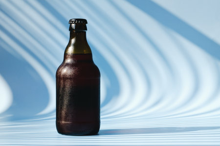 Top view of glass brown beer bottle, glass of beer against blue background close up. food lifestyle. Alcoholic drink production. Copy space, mockup. flat layの写真素材