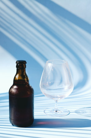 Top view of glass brown beer bottle, glass of beer against blue background close up. food lifestyle. Alcoholic drink production. Copy space, mockup. flat layの写真素材