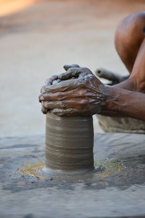 Hands working on pottery wheel and making a potの写真素材
