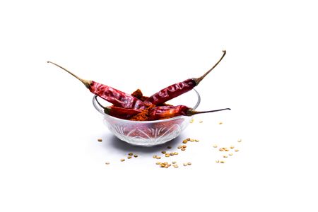 Indian red chilli with powder in a bowl isolated on white backgroundの写真素材