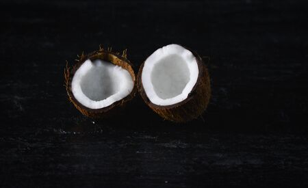 Coconut with half on a dark background. Organic healthy food concept.