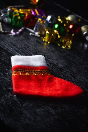 Red christmas sock on dark wooden background. Concept of christmas or holiday.の写真素材