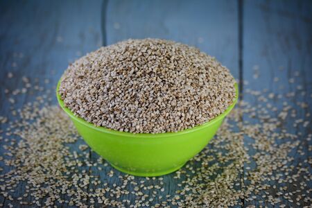 Sesame seeds in bowl on wooden backgroundの写真素材
