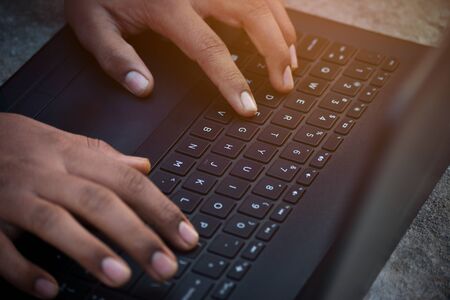 Businessman using laptop with hands typing on a keyboardの写真素材