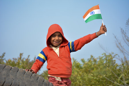 TIKAMGARH, MADHYA PRADESH, INDIA - JANUARY 22, 2020: Unidentified indian village little boy holding indian flag.のeditorial素材
