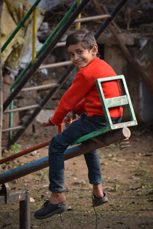 TIKAMGARH, MADHYA PRADESH, INDIA - JANUARY 29, 2020: Little boy having fun on a swing.