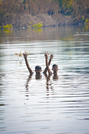 TIKAMGARH, MADHYA PRADESH, INDIA - NOVEMBER 13, 2019: Indian village boys swimming in the fresh river water.のeditorial素材