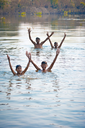 TIKAMGARH, MADHYA PRADESH, INDIA - NOVEMBER 13, 2019: Indian village boys swimming in the fresh river water.のeditorial素材