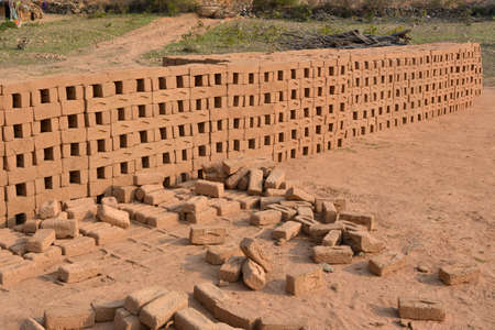 Raw brick laid out in stacks for drying. Bricks in a brick factory. Traditional production of clay...