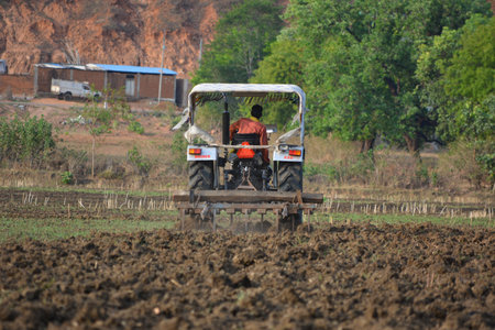 TIKAMGARH, MADHYA PRADESH, INDIA - JUNE 15, 2020: Indian farmer with tractor preparing land for...