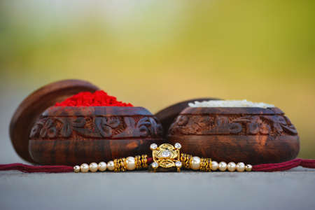 Raksha bandhan rakhi with rice grains and kumkum. A traditional indian wrist band which is a symbol of love between Brothers and Sistersの素材 [FY310151393941]