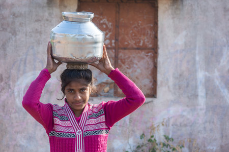 TIKAMGARH, MADHYA PRADESH, INDIA - JANUARY 23, 2021: An unidentified indian village girl carry water...