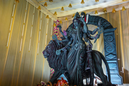 A beautifully crafted idol of Goddess Durga with multiple arms holding various weapons, seated on a...