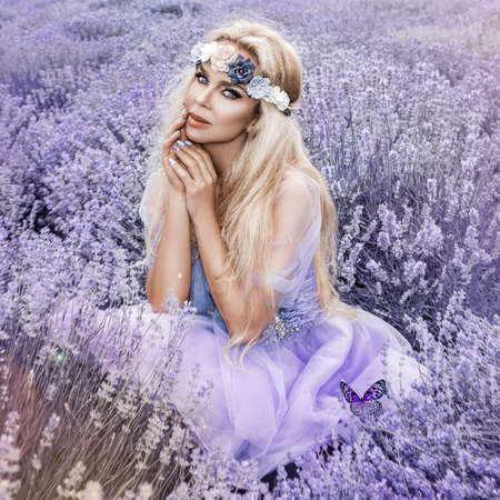 Beautiful model walking in spring or summer lavender field in sunrise. Blond long haired girl in lavender field - Imageの写真素材