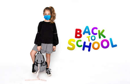 Coronavirus covid-19 virus. Back to school concept. Cute child girl with backpack and surgical mask during the coronavirus going to school isolated on white - Imageの写真素材