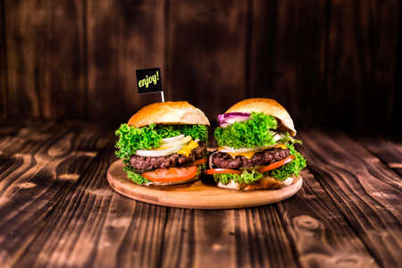 Burger on wooden table. Close-up of home made big burger. Wooden table. Cheeseburger day.の写真素材
