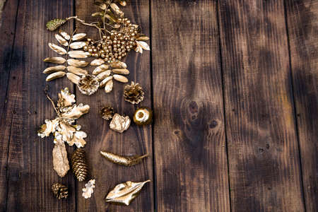 Christmas minimalistic gold and simple composition on a wood background. Christmas decor, gold decorations on wodd. Flat lay, top view with copy space. Autumn winter background.の写真素材