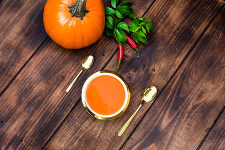 Roasted pumpkin and carrot soup with cream and pumpkin seeds on white wooden background. Copy space. Flat lay. Food porn.の写真素材