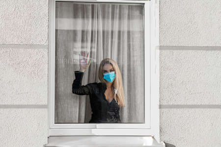 Sick woman of corona virus looking through the window and wearing mask protection and recovery from...