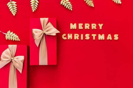 Christmas red background with Christmas gift and cookies decor. Top view with copy space. Minimalism. Merry Christmas.の写真素材