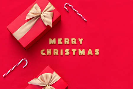 Christmas red background with Christmas gift and cookies decor. Top view with copy space. Minimalism. Merry Christmas.の写真素材