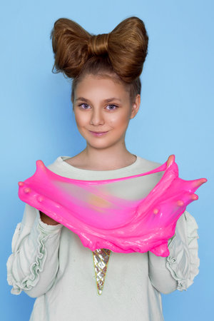 Kid Playing Hand Made Toy Called Slime, Hands Squeeze Isolated on blue background - Image. Happy kid with slime.の写真素材