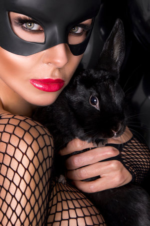 Beautiful Blond Woman in a Carnival Mask on balloons background. Sexy masked girl. Easter bunny.の写真素材