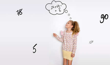 Cute little girl is a student at the blackboard at school and counts math. Schoolgirl concept. Draw...