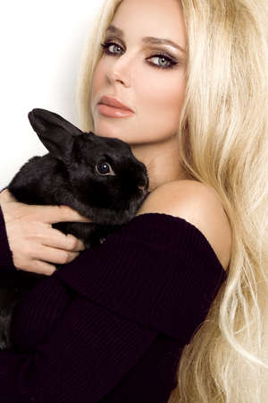 happy girl holding cute furry rabbit isolated on white. Girl with rabbit bunny.の写真素材